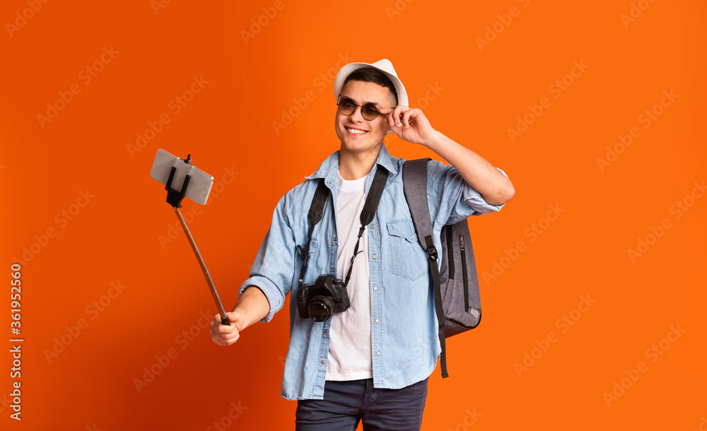 Young male traveler with glasses taking positive selfie Young male traveler with glasses taking positive selfie