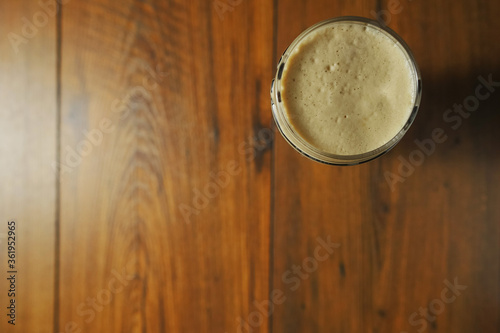 Pint glass of a dark stout beer on a wooden table in a pub. Alcohol beverage industry concept. Copy space. Top down view. photo