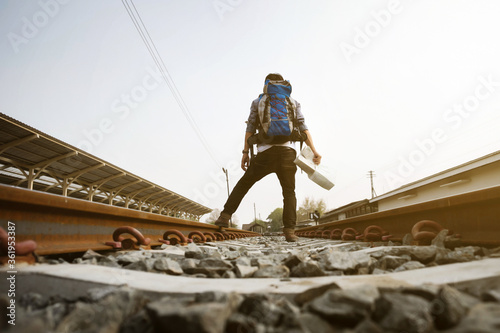 Traveler with backpack and map on railway vintage tone. travel concept.