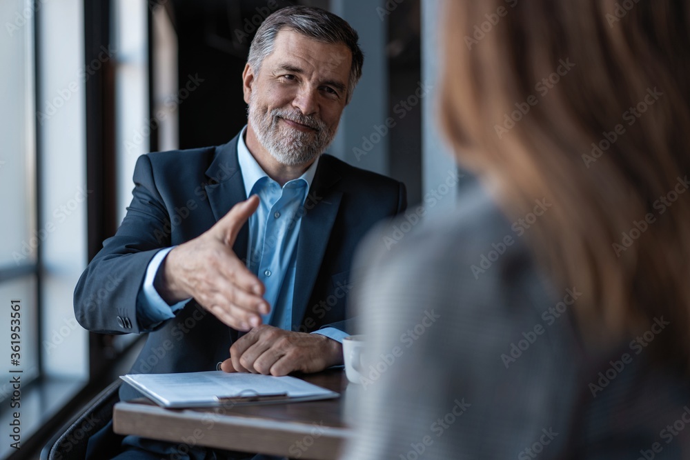 Happy recruiting manager congratulating female vacancy candidate, shaking hand. New job concept Happy recruiting manager congratulating female vacancy candidate, shaking hand. New job concept