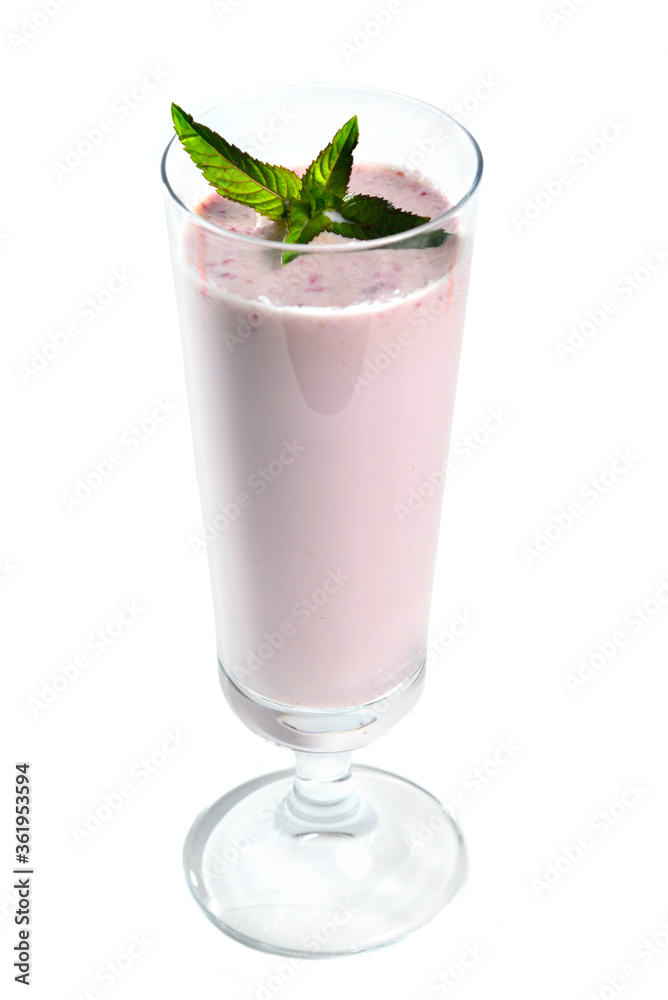 Blueberry milk shake in tall glass on white background garnished with mint leaves Blueberry milk shake in tall glass on white background garnished with mint leaves