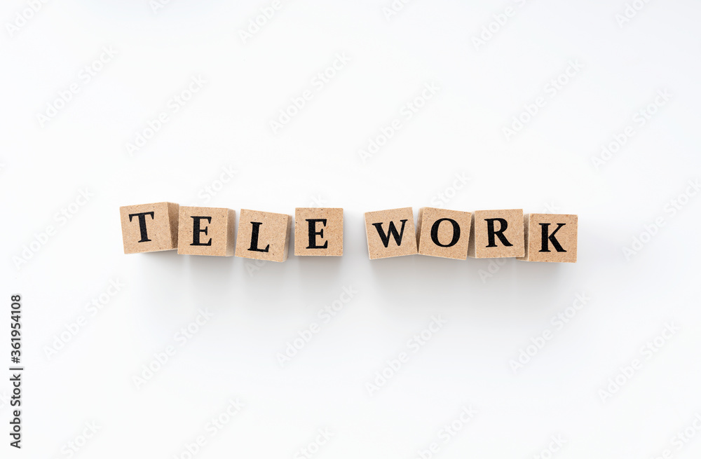 A wooden block with the word tele work written on it on a white background A wooden block with the word tele work written on it on a white background
