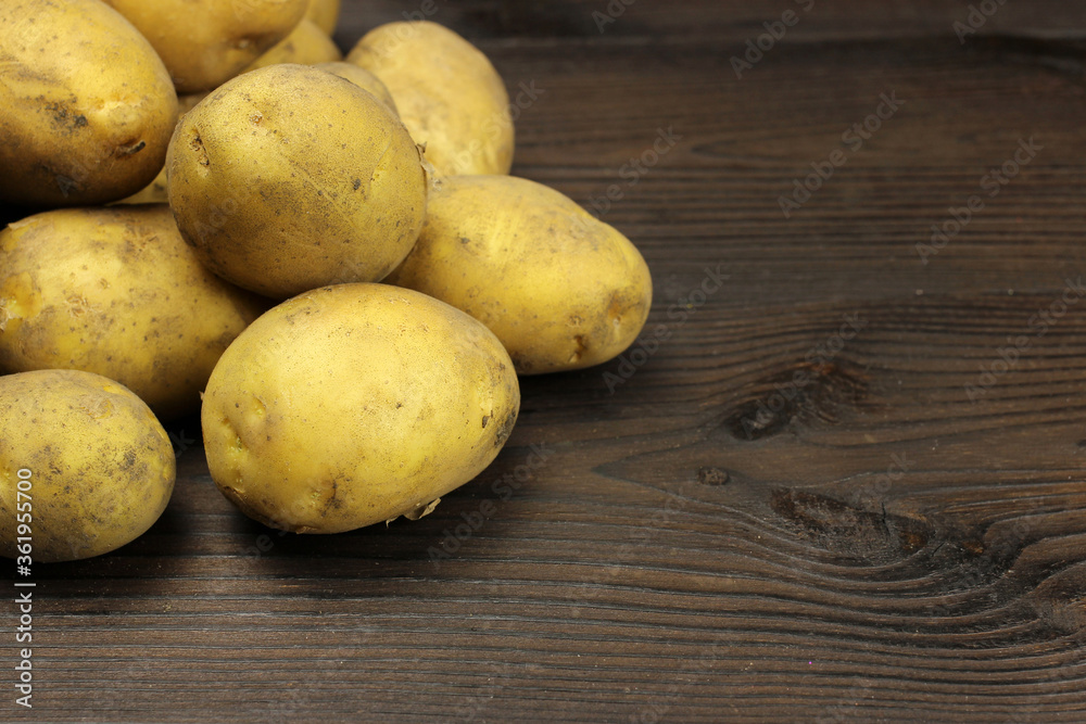 Raw organic potatoes on a wooden background Raw organic potatoes on a wooden background