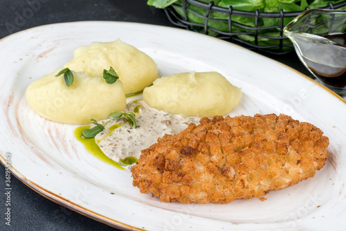 Pozharsky cutlet with potatoes and sauce on a white plate