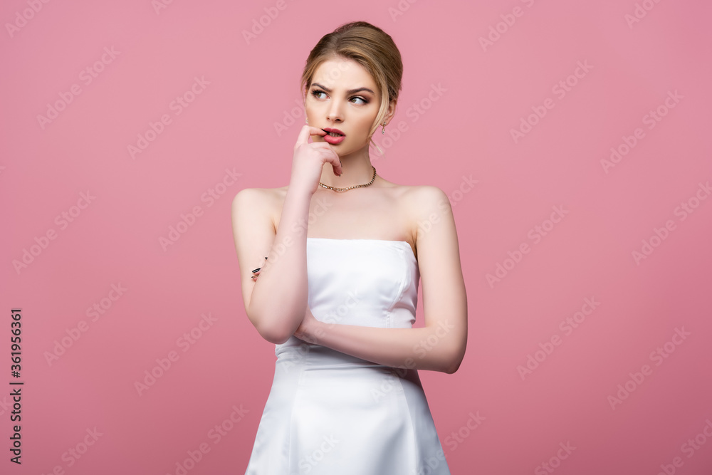 pensive bride in white wedding dress looking away isolated on pink pensive bride in white wedding dress looking away isolated on pink