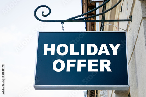 HOLIDAY OFFER. Shop, cafe, restaurant or hotel signboard. City center and old town