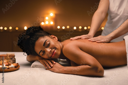 African american woman enjoying romantic atmosphere during body massage