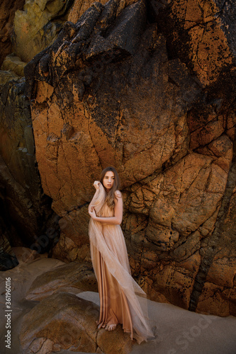 beautiful young woman in elegant dress on the beach