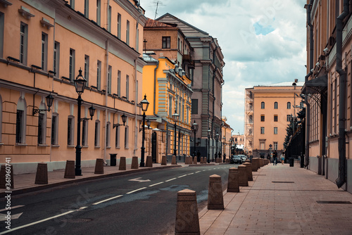 A deserted narrow street in the Central part of the city with low-rise stone buildings