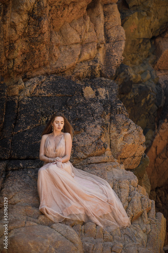 beautiful young woman in elegant dress on the beach