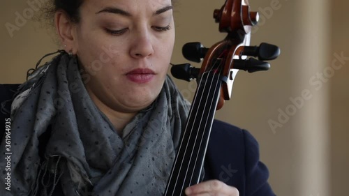 Mujer tocando el violonchelo con pasión durante un concierto al aire libre.