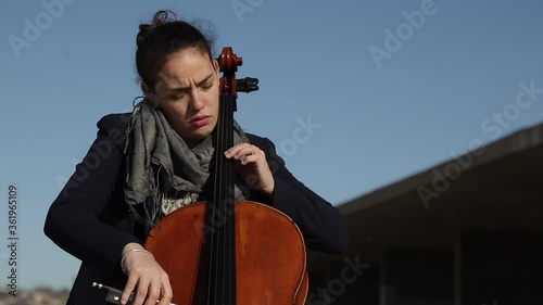 Mujer tocando con pasión el violonchelo durante un concierto.