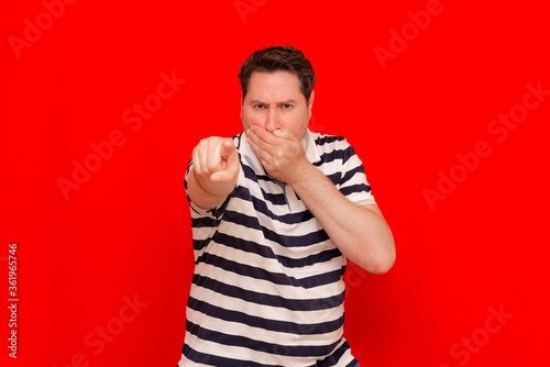 Hey you  Portrait of calm man wearing striped t shirt pointing finger  indicating direction to camera