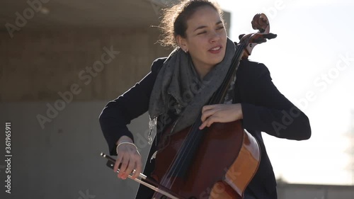 Mujer tocando con pasión el violonchelo al aire libre