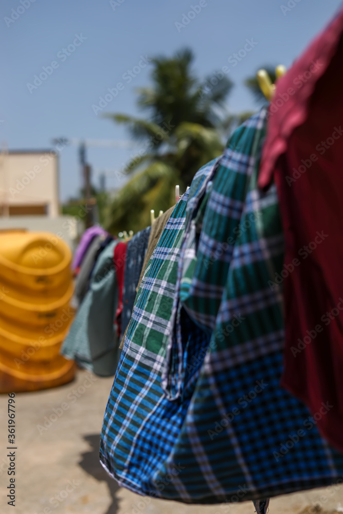 wet laundry drying on clothes line against a blue sky wet laundry drying on clothes line against a blue sky
