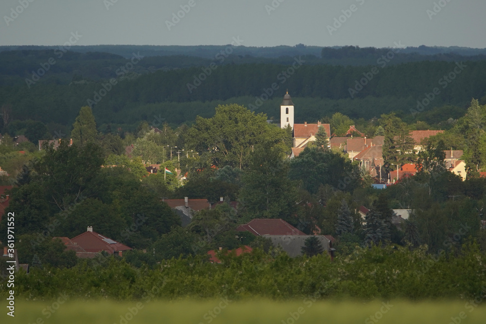 Telephoto photo of a city photographed from a distance. The rays of the sun on the church