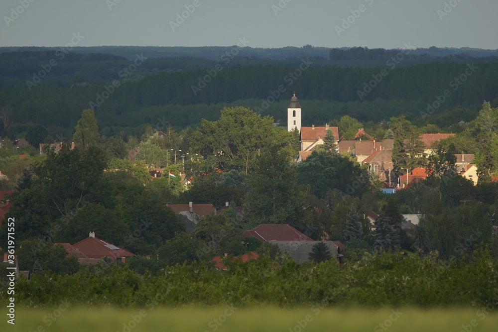 Telephoto photo of a city photographed from a distance. The rays of the sun on the church Telephoto photo of a city photographed from a distance. The rays of the sun on the church