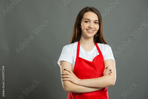 Obraz na plátně Portrait of young female supermarket employee standing with arms crossed