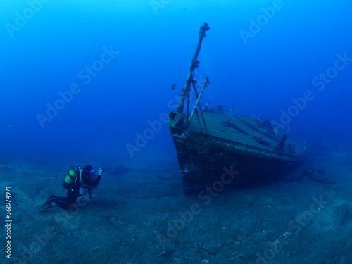 scuba divers exploring ship wreck underwater ocean scenery photography  © underocean