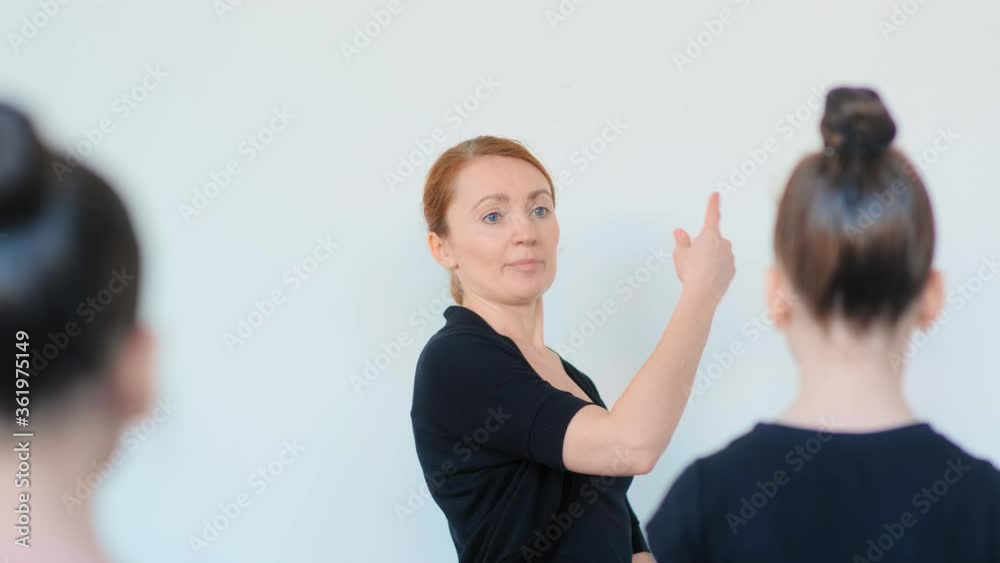 professional ballet teacher explains little girls dance moves for beginners standing in studio at wall slow motion professional ballet teacher explains little girls dance moves for beginners standing in studio at wall slow motion