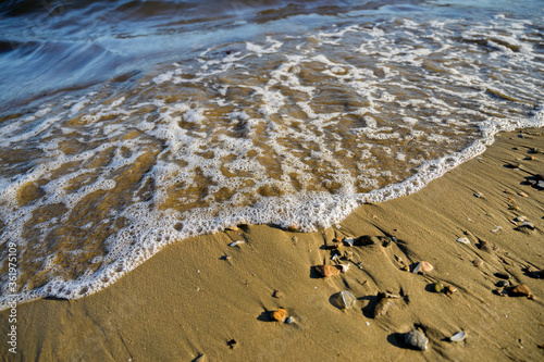 Waves at the seashore at sunset. Selective focus with shallow depth of field. photo