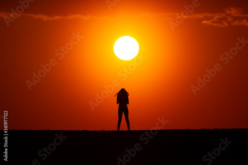 Young woman silhouette at sunset on a farm. © Varga_photography