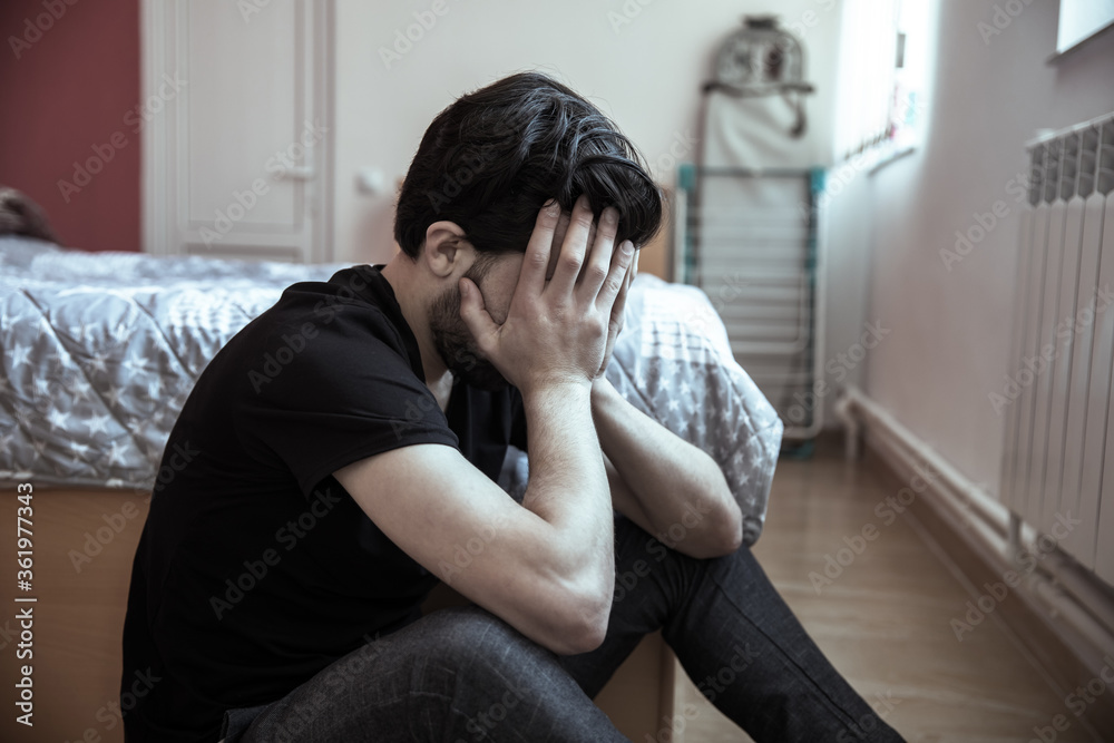man sitting in bedroom floor