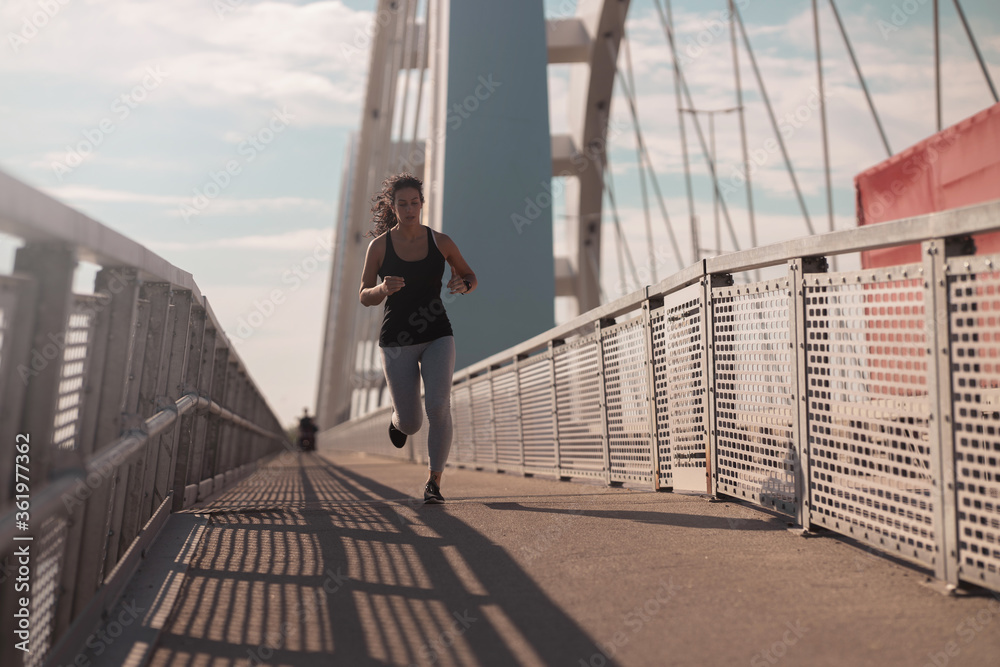 Young woman running at the Bridge Young woman running at the Bridge
