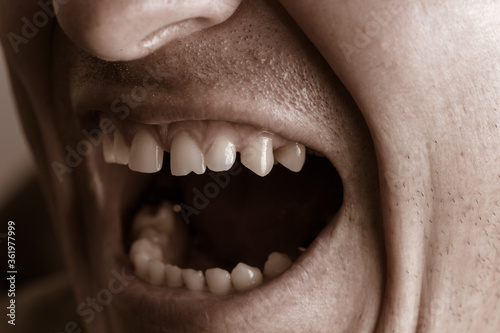 Close-up lips and mouth of a man screaming.
