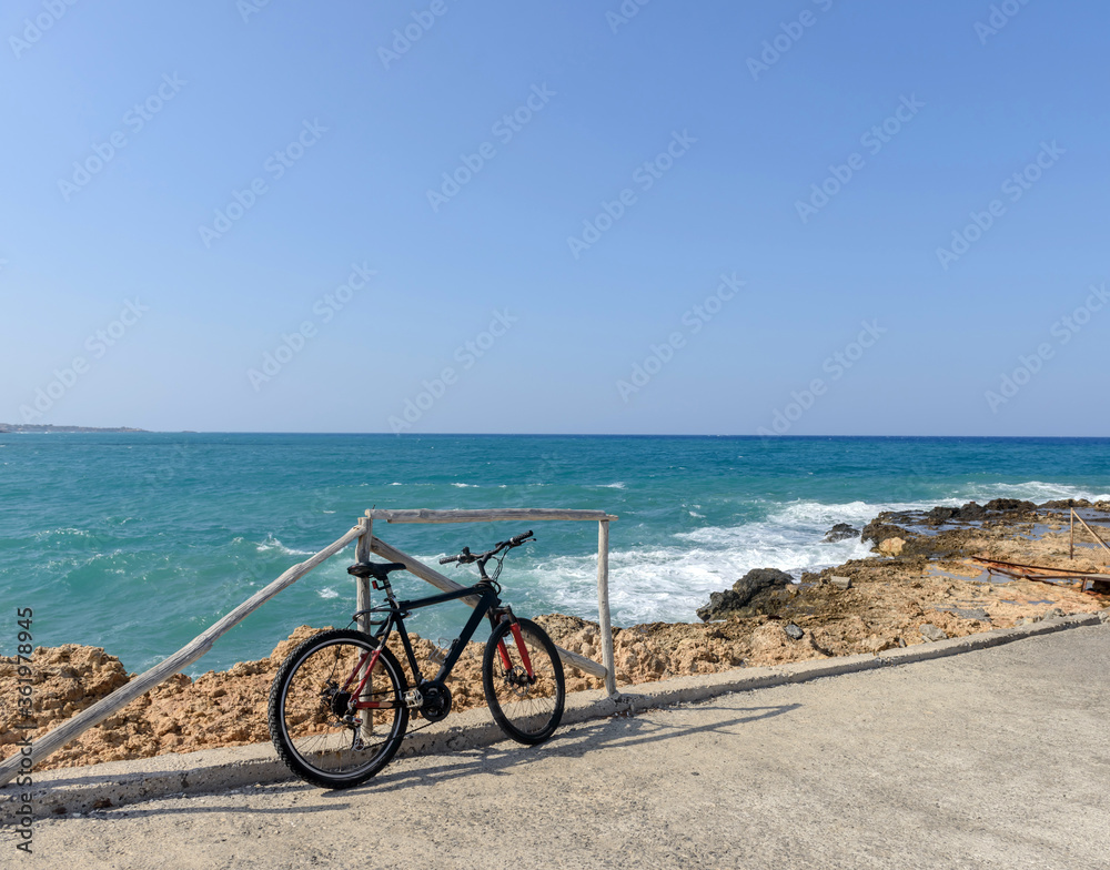 Fototapeta premium Bicycle parked near the sea standing on the beach. Greece. Велосипед на берегу моря. Bicycle