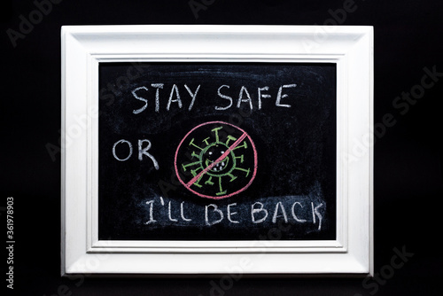 Blackboard with the sign stay safe or virus will be back on the black blackground. Second lockdown