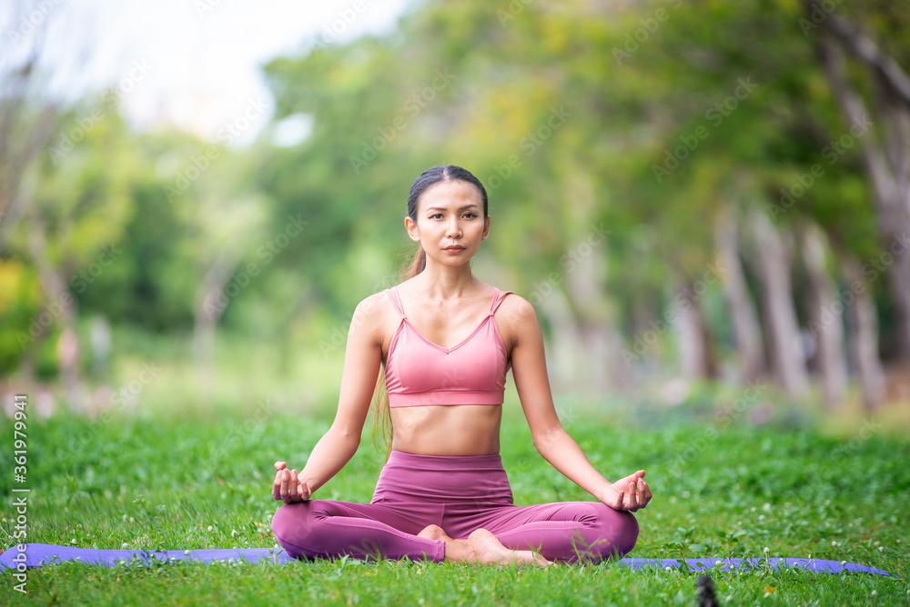 Asian model poses yoga in a park on a natural green background, health care concept, beautiful body structure, fit body Asian model poses yoga in a park on a natural green background, health care concept, beautiful body structure, fit body