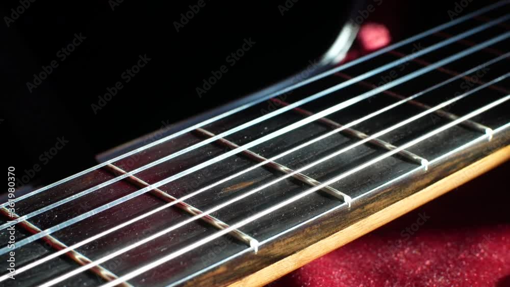 Guitar fretboard with frets and strings close up sliding shot