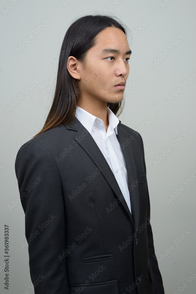 Young Asian businessman with long hair thinking Young Asian businessman with long hair thinking