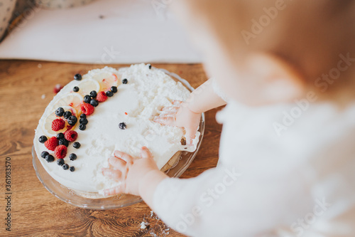 Baby girl dressed up in bright clothing celebrates her one year birthday at home