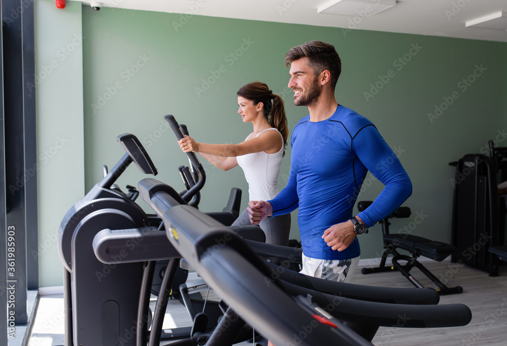 Smiling couple exercising at home gym. Smiling couple exercising at home gym.