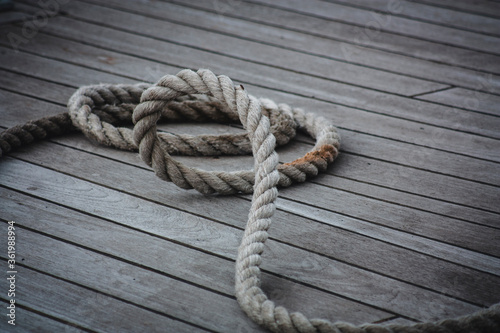 Thick rope coiled on a wooden floor.