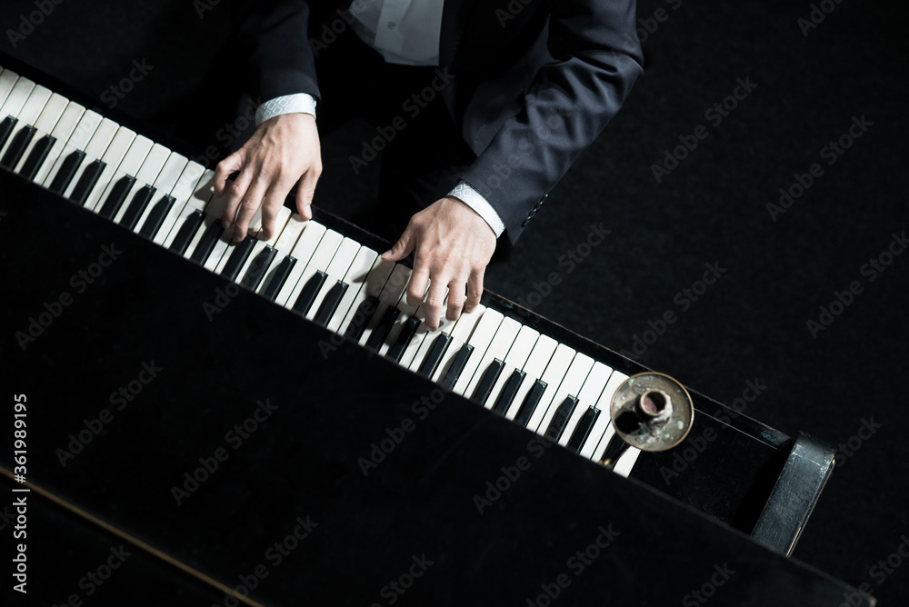 A man plays the piano, close-up of hands, top down. Concert pianist