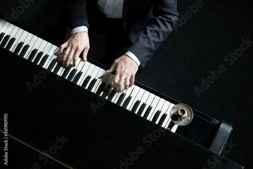 Obraz na płótnie A man plays the piano, close-up of hands, top down. Concert pianist w salonie