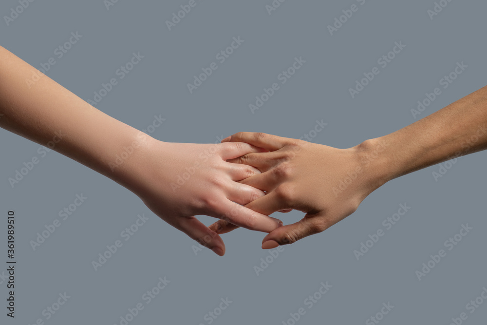 Close-up of people from different races interlocking fingers