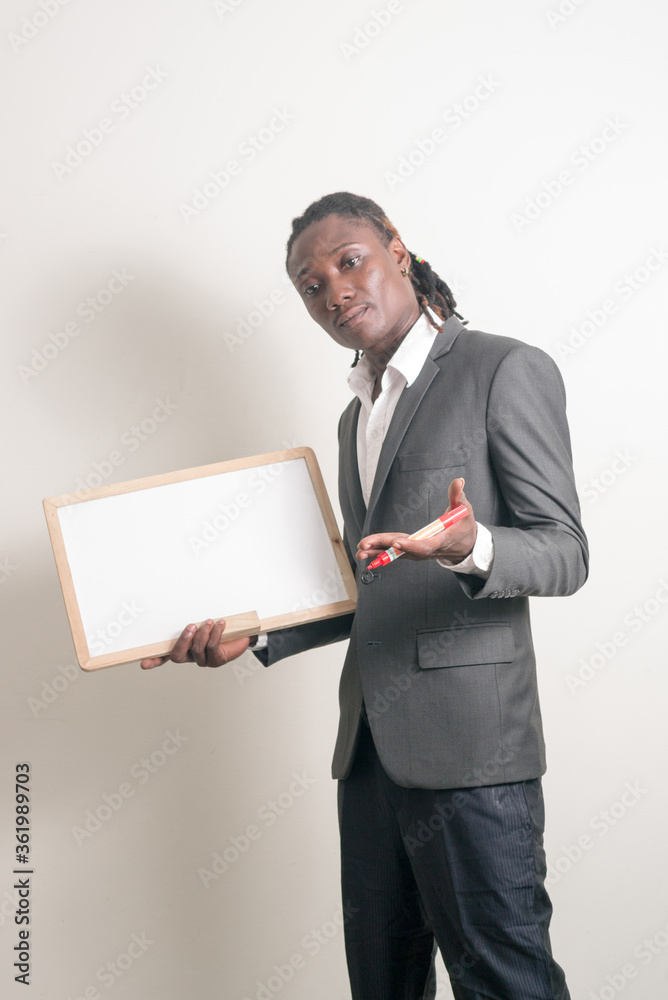 Young handsome African businessman with dreadlocks holding white board Young handsome African businessman with dreadlocks holding white board