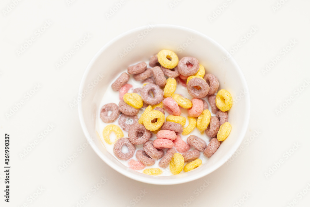 Colorful cereal with milk on a glass bowl on white background Colorful cereal with milk on a glass bowl on white background