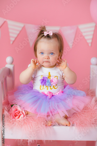 Smash cake party. Little cheerful birthday girl with first cake. Happy infant baby celebrating his first birthday. Decoration and photo zone for first year. One year baby celebration. Pink decor.