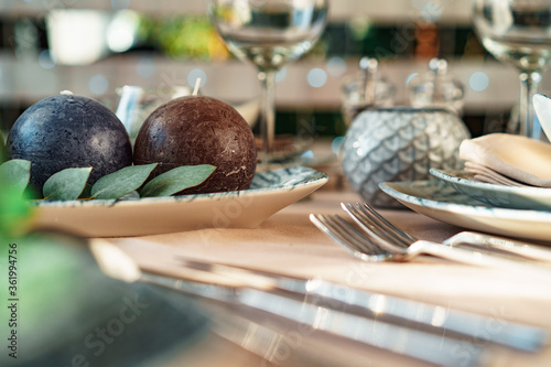 Beautiful elegant table setting with green stylish dishware and silver cutlery