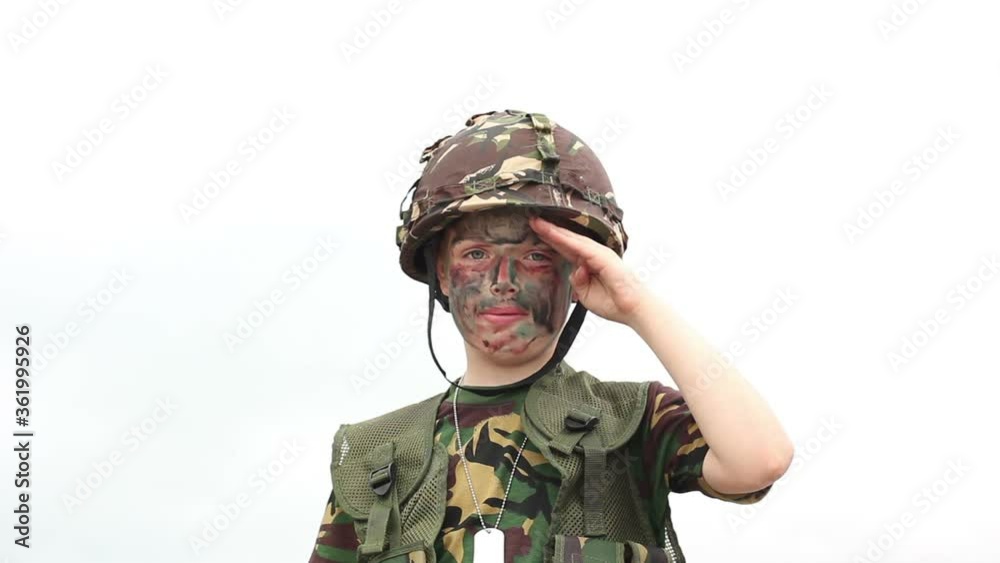 Child dressed as a Soldier in camouflage Army uniform. He is saluting to the camera. Tilt up. Stock Video Clip Footage Child dressed as a Soldier in camouflage Army uniform. He is saluting to the camera. Tilt up. Stock Video Clip Footage