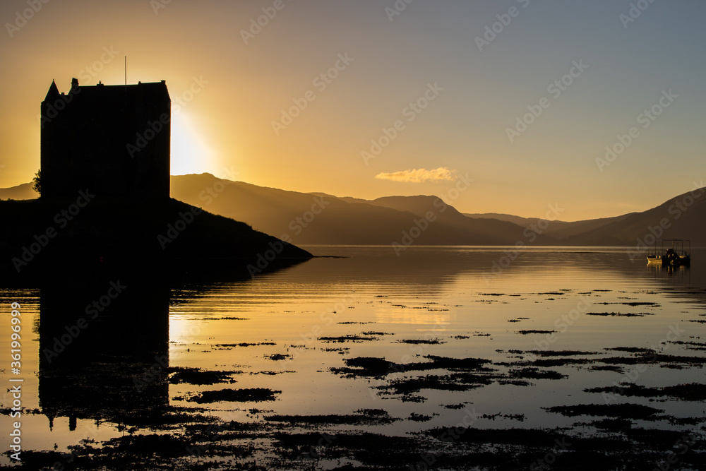 Silhouette of a scottish castle on an island at sunset