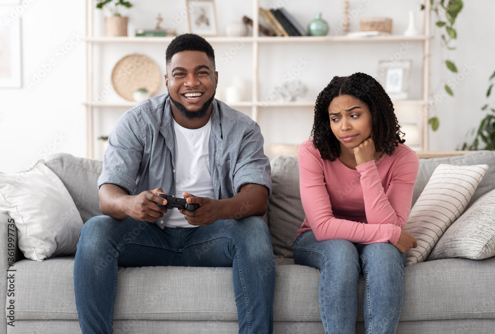 Fototapeta premium Boring Date. Excited Black Guy Playing Video Games And Ignoring Girlfriend Next To Him