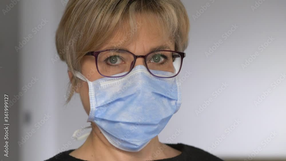 serious woman wearing eyeglasses and surgical mask thinking about epidemic serious woman wearing eyeglasses and surgical mask thinking about epidemic