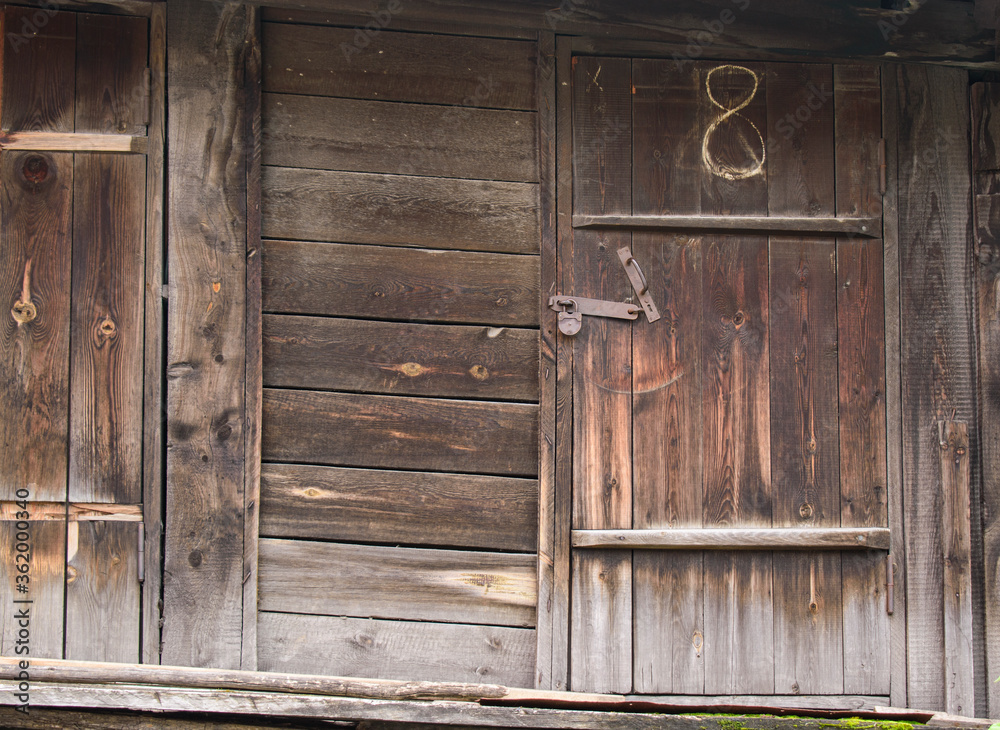 Old wooden shed. Closed door to a metal lock.
Old wooden shed. Closed door to a metal lock.