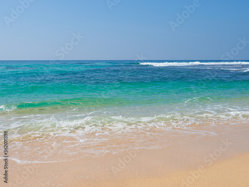 Ocean waves run over the beautiful beach on coast of Sri Lanka, Mirissa. Indian ocean.